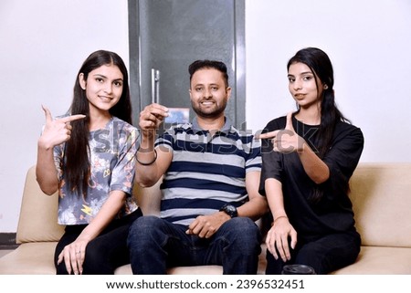 Indian people group showing credit card while sitting on sofa
