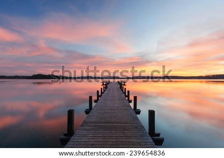 A wooden jetty at lake Woerthsee photographed early in the morning.