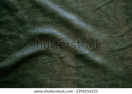Blurred of dark green silk satin. Soft folds. Fabric. green luxury background. Space for design. Wavy lines. Banner. Flat lay, top view table. Beautiful. Elegant. Birthday, Christmas, Valentine's Day.