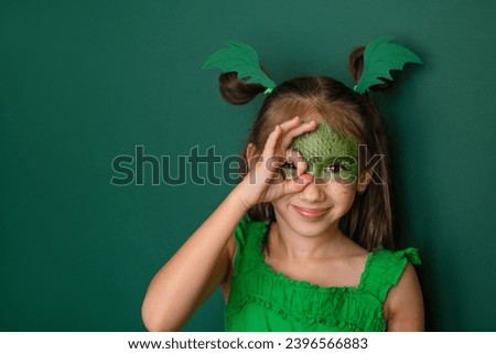 A beautiful girl dressed up as a dragon makes a gesture with her fingers ok. The symbol of the 2024 new year according to the Eastern calendar