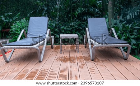 pair of chaise lounge chairs in the swimming pool at luxury hotel Royalty-Free Stock Photo #2396573107