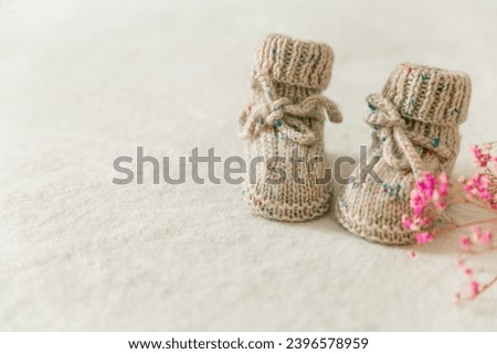 Knitted baby socks, booties on a white background with copy space. Pregnancy and motherhood concept, first birthday banner, handmade socks, baby warm clothes, handmade knitted socks, hobby Royalty-Free Stock Photo #2396578959