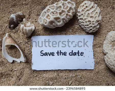 Save the date writing on beach sand background.