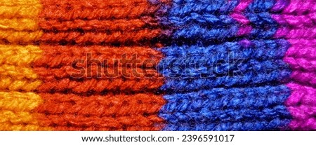 Pattern fabric made of wool. Handmade knitted fabric red blue and orange wool background texture