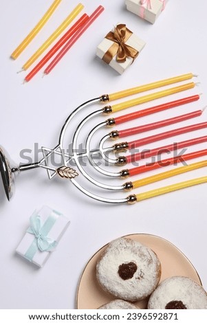Flat lay composition with Hanukkah menorah and donuts on white background
