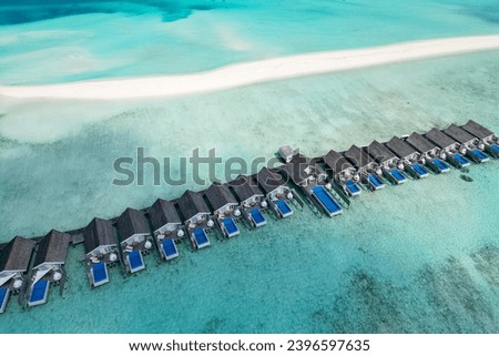 stunning blue ocean and sandy lux hotels on water top drone aeral view Maldives beach copyspace for text Royalty-Free Stock Photo #2396597635