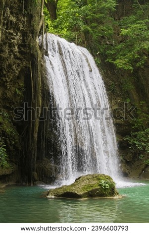 Erawan National Park in Thailand. Erawan Waterfall is a popular tourist destination and famous for its emerald blue water. Deep forest in tropical climate with fantasy atmosphere. Royalty-Free Stock Photo #2396600793