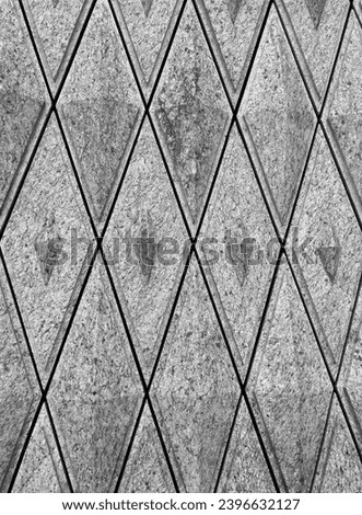 Carved grey granite stone in geometry pattern on the wall 