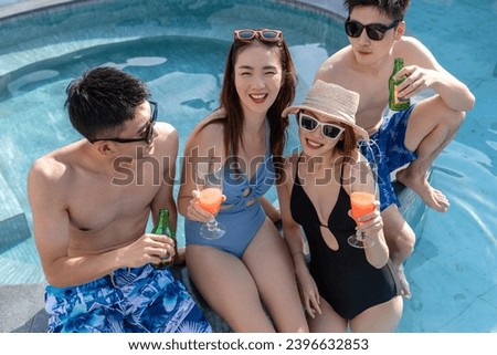 Young friends sitting in the swimming pool to chat