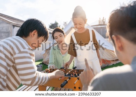 The happy family of four in outdoor play football on the table