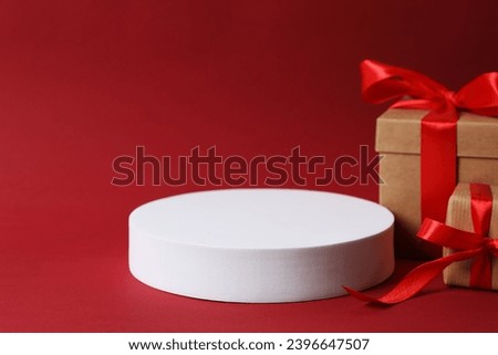 Bright gifts near a white podium with copy space. Christmas or New Year celebration concept