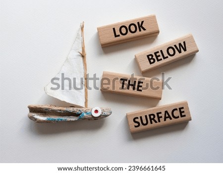 Look below the surface symbol. Concept word Look below the surface on wooden blocks. Beautiful white background with boat. Business and Look below the surface concept. Copy space