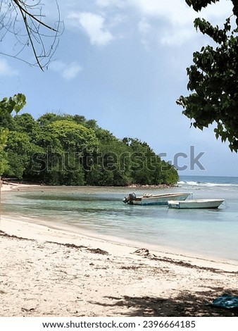 This a Guadeloupe beach picture taken during the afternoon. We can also see two littel boat for fishing
