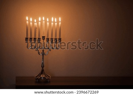 Hanukkah menorah, or hanukkiah in the light of the sun at sunset for Jewish holiday Hanukkah. Hanukkah lamp, nine-branched candelabrum with burning candles. Royalty-Free Stock Photo #2396672269