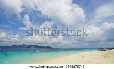 Beach featuring pristine white sands, a calm turquoise ocean, and a sunlit sky of fluffy clouds. Beach and sea with blue sky and white cloud background.