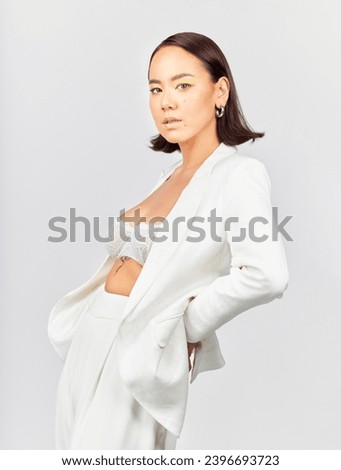 Portrait, fashion and asian woman in studio with confidence, style and cool clothes against a white background. Stylish, pose and Japanese female model with trendy outfit, attitude and aesthetic Royalty-Free Stock Photo #2396693723