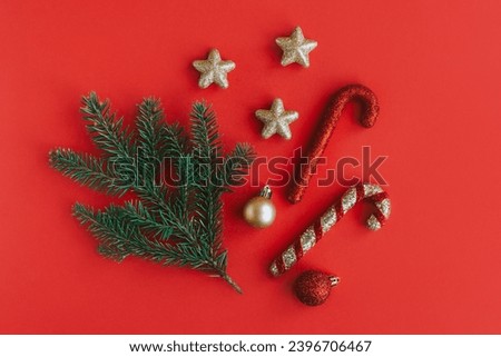 Spruce branch and Christmas ornaments on a red background. Holiday concept. Place for text.