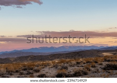 sunset in the desert, image shows the beautiful golden sunset glow in the navada desert with some clouds and a mountain view in the background, taken october 2023