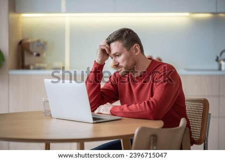 Disappointed hopeless unemployed middle aged man jobseeker sitting at table, reading advertisements on web sites, looking through vacancies, hunting for job. Depressed man after dismissal, job cut Royalty-Free Stock Photo #2396715047