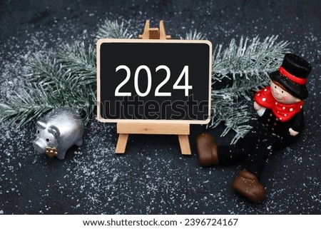 Lucky pig, chimney sweep and the number 2024 on a chalkboard.