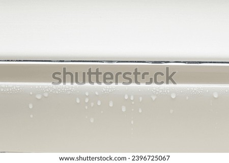 Water droplets condensation on white metal-plastic frame of window indoors room. High humidity. Moisture condensation problems, hot water vapor condensed on window in cold season