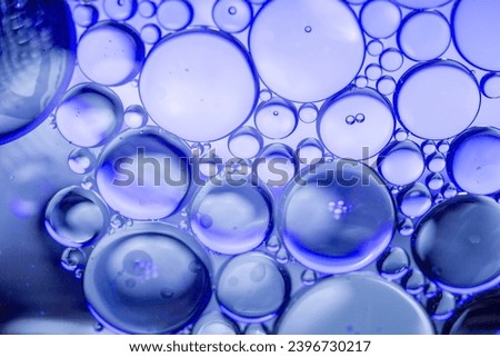 Blue pastel drops of oil or serum texture background. Abstract blue fluid with bubbles. Macro shot
