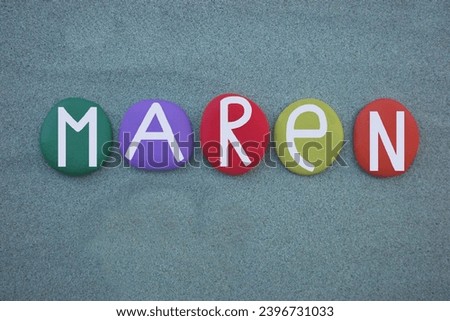 Maren, Germanic feminine given name composed with hand painted multi colored stone letters over green sand