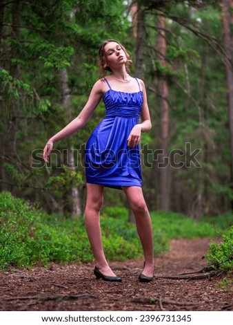Beautiful teenager girl in high fashion dress posing in a forest park. Prom or special event. Young lady in classic outfit. Model in designer clothes, slim athletic body type.
