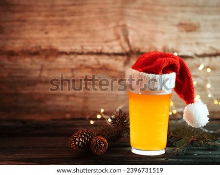 Christmas beer in a Santa hat on a wooden background