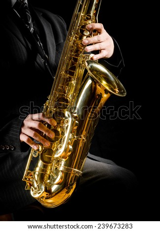 saxophone in male hands on a black background