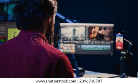 Videographer using smartphone to record himself explaining basic editing techniques for beginners, selling online course. Professional video editor filming footage manipulating tutorial Royalty-Free Stock Photo #2396738787
