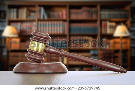 Gavel Resting on a Table Inside a Law Office with Bookshelf of Law Books in the Background.