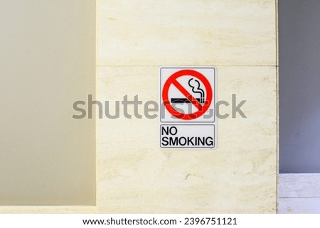 A "No Smoking" sign affixed to a marble wall, symbolizing health regulations and the prohibition of smoking in the area
