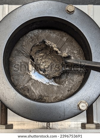 Hobby lead casting pot with molten lead and dross impurities floating on the surface Royalty-Free Stock Photo #2396753691