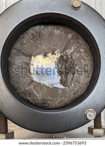 Hobby lead casting pot with molten lead and dross impurities floating on the surface Royalty-Free Stock Photo #2396753693