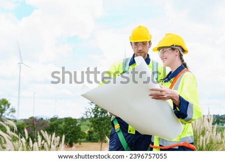 Architectural engineering worker builders looking for wind turbine blueprint drawings for wind turbine construction at windmill field farm. Alternative renewable energy for clean energy concept.