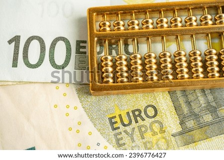 Gold abacus on Euro banknote money, economy finance exchange trade investment concept. Royalty-Free Stock Photo #2396776427
