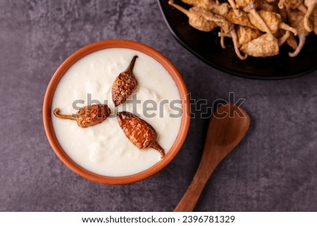 Bowl of homemade sour cream curd yogurt Dahi fresh herbs curry leaf Kerala India. Dairy product obtained coagulating milk process curdling. probiotic food tasty curd rice curry spices Royalty-Free Stock Photo #2396781329