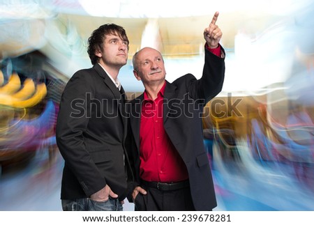 Two businessmen in business center. Senior businessman pointing at something