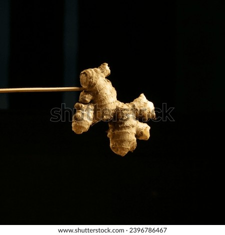 various kinds of kitchen spices such as turmeric, turmeric powder, ginger, red chili, coriander, lime leaves, garlic and red, cinnamon, dark black background, with a levitation photo concept