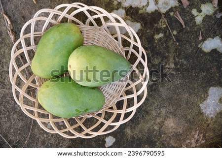 Three fresh mangoes in a basket