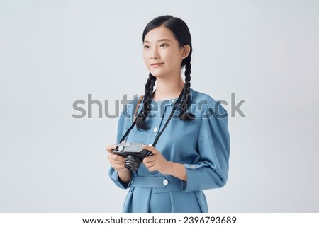 Young beautiful woman photographer taking images with digital camera and smiling