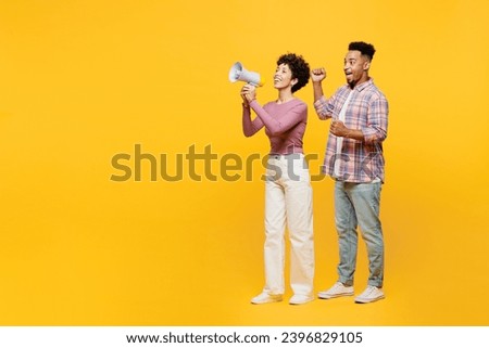 Full body young couple two friends family man woman of African American ethnicity wear purple casual clothes together hold megaphone scream announces sale Hurry up isolated on plain yellow background