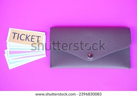 Leather envelope and pile of paper tickets. Pink background. Concept, tickets for passing or enter to join activity or public vehicles. Tickets for playing games. Teaching aids.          