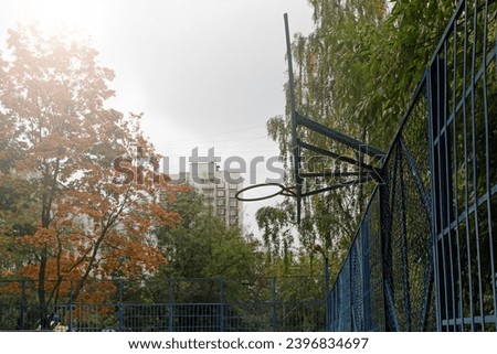 Basketball hoop with autumn leaves. Empty outdoor basket basketball court in autumn