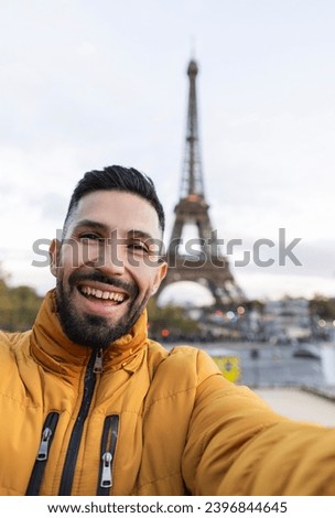 happy latin man taking a selfie in paris with the eiffel tower in the background