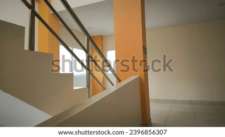 A staircase with a white and orange wall suitable for interior design, architectural concepts, home renovation, and real estate marketing materials. Ideal for showcasing modern