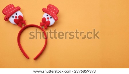 cute Christmas headbands with snowman's isolate on a light orange backdrop. concept of joyful Christmas party,New year is coming soon, festive season decoration with Christmas elements