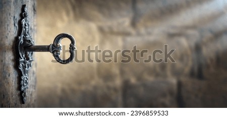Old key in keyhole, macro shot. Gothic style. Key to knowledge. Concept and Idea for History, education, security, imprisonment, dungeon, prison background.  Royalty-Free Stock Photo #2396859533