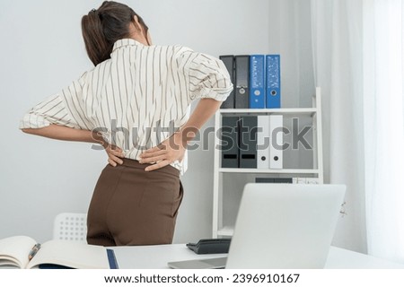 woman holding her lower back while and suffer from unbearable pain health and problems, chronic back pain, backache in office syndrome, scoliosis, herniated disc, muscle inflammation Royalty-Free Stock Photo #2396910167